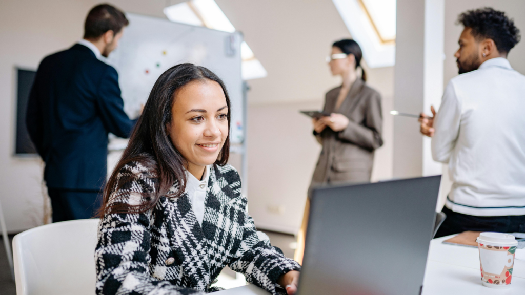 Professional using ChatGPT to write better work emails on a laptop in an office environment